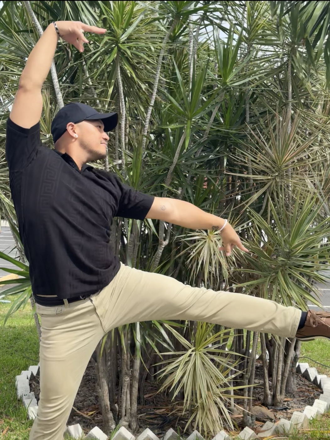 Zano in an extended dance line, one arm overhead and one reaching outward.