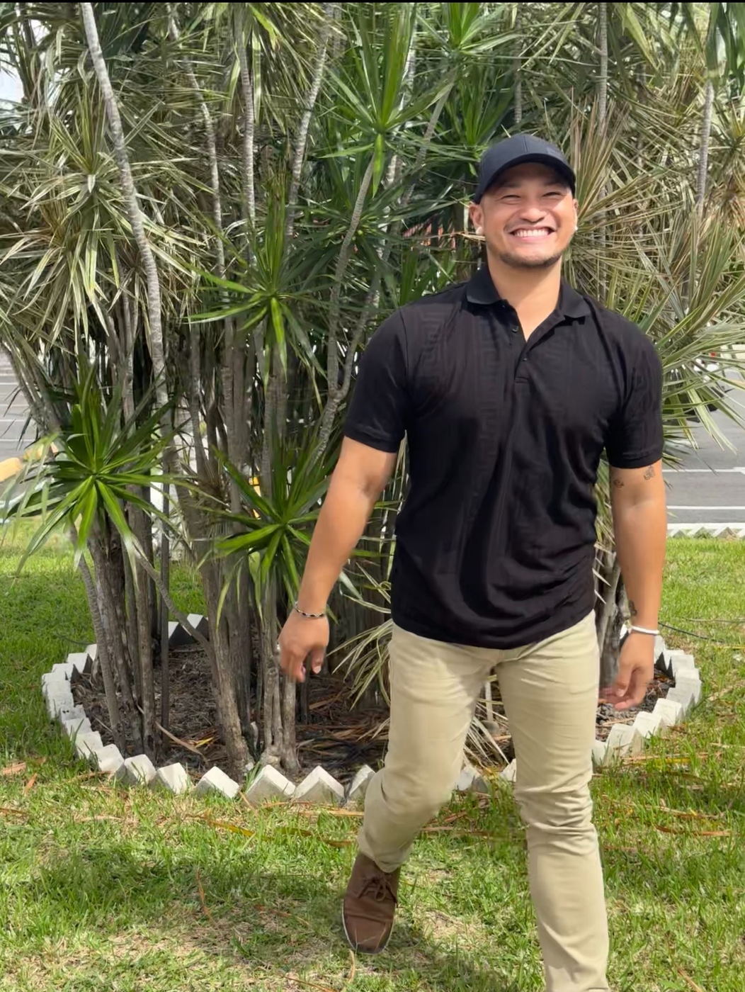 Zano J. Manzano standing outdoors, laughing.